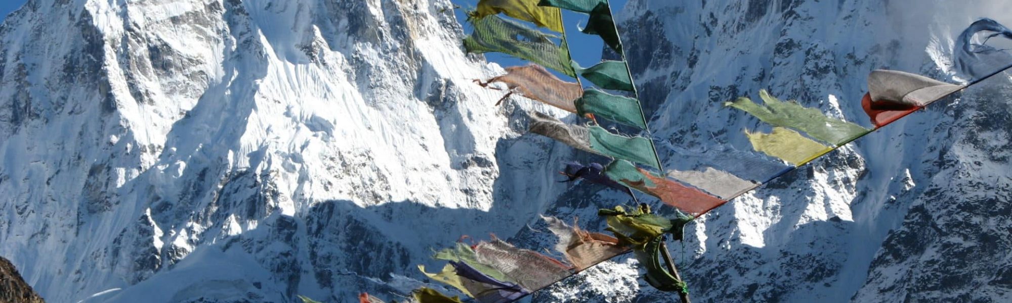 Nepal | Trek zum Kanchenjunga: Gebetsfahnen flattern im Wind, im Hintergrund der Kanchenjunga / kurz: "Kantsch"